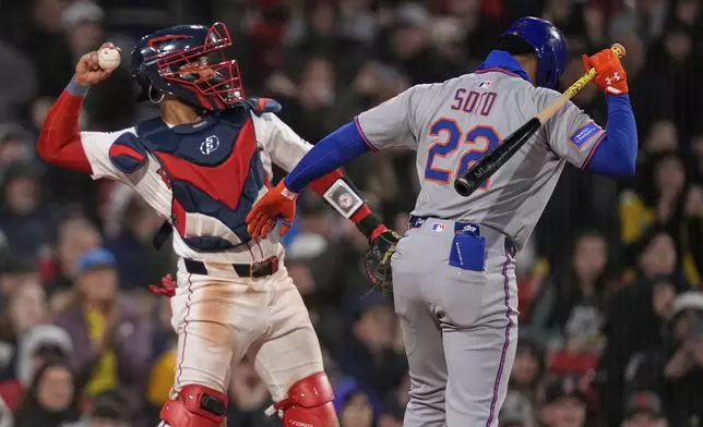 New York Mets' Juan Soto (22) heads to the dugout after striking out, as Boston Red Sox catcher Carlos Narvaez throws the ball back to the pitcher, in the sixth inning of a baseball game at Fenway Park, Wednesday, May 21, 2025, in Boston. (AP Photo/Charles Krupa)