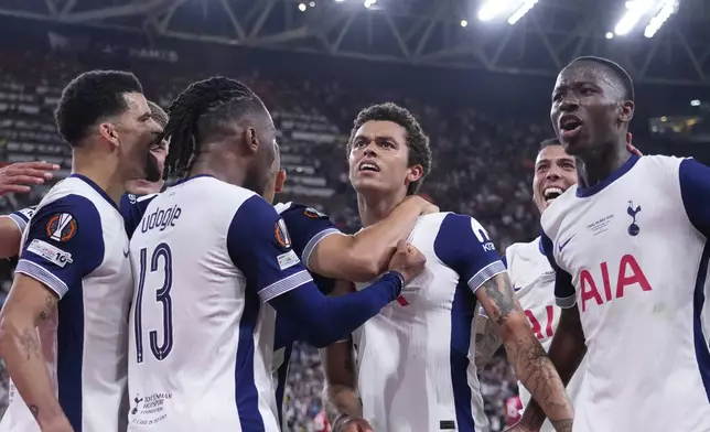 Tottenham's Brennan Johnson, centre, celebrates after scoring his side's opening goal during the Europa League final soccer match between Tottenham Hotspur and Manchester United at the San Mames Stadium in Bilbao, Spain, Wednesday, May 21, 2025. (AP Photo/Jose Breton)