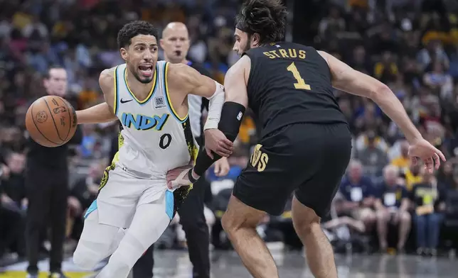 Indiana Pacers guard Tyrese Haliburton (0) drives to the basket against Cleveland Cavaliers guard Max Strus (1) in the second half of Game 4 in the Eastern Conference semifinals of the NBA basketball playoffs in Indianapolis, Sunday, May 11, 2025. (AP Photo/Michael Conroy)