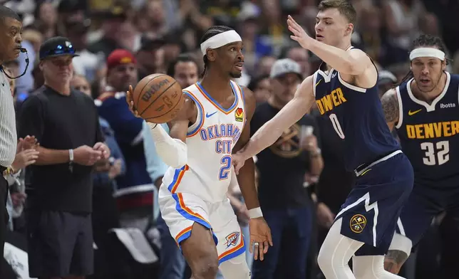 Oklahoma City Thunder guard Shai Gilgeous-Alexander (2) looks to pass the ball as Denver Nuggets guard Christian Braun (0) defends in the first half of Game 4 in the Western Conference semifinals of the NBA basketball playoffs Sunday, May 11, 2025, in Denver. (AP Photo/David Zalubowski)
