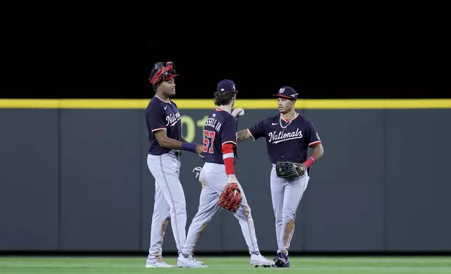 From left, Washington Nationals left fielder James Wood, center fielder Robert Hassell III, and right fielder Daylen Lile celebrate after the team's win in a baseball game against the Seattle Mariners, Wednesday, May 28, 2025, in Seattle. (AP Photo/Ryan Sun)