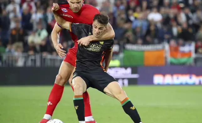 Venezia's Gaetano Oristanio, right, and Fiorentina's Marin Pongracic, left, challenge for the ball during the Serie A soccer match between Venezia and Fiorentina in Venice, Italy, Monday, May 12, 2025. (Paola Garbuio/LaPresse via AP)