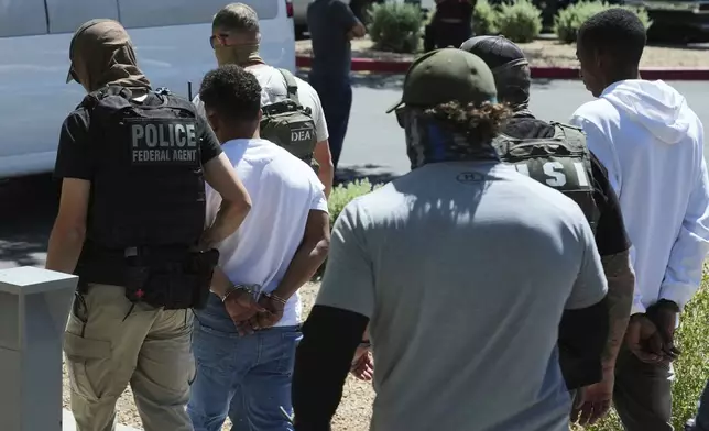 A variety of federal police remove two persons after an immigration court hearing outside an immigration court, Wednesday, May 21, 2025, in Phoenix. (AP Photo/Ross D. Franklin)