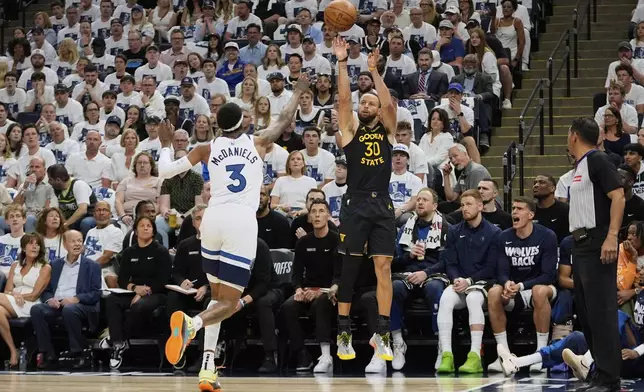 Golden State Warriors guard Stephen Curry (30) shoots over Minnesota Timberwolves forward Jaden McDaniels (3) during the first half of Game 1 of an NBA basketball second-round playoff series, Tuesday, May 6, 2025, in Minneapolis. (AP Photo/Abbie Parr)