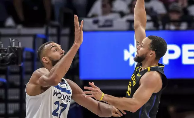 Stephen Curry (30) shoots over Rudy Gobert (27) in the first half as the Golden State Warriors played the Minnesota Timberwolves in Game 1 of the Second Round of the NBA Playoffs at Target Center in Minneapolis, Minn., on Tuesday, May 6, 2025. ( Carlos Avila Gonzalez/San Francisco Chronicle via AP)