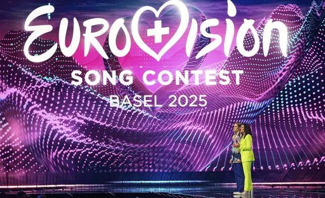 Hosts Hazel Brugger, left and Sandra Studer, on stage during the first semi-final of the 69th Eurovision Song Contest, in Basel, Switzerland, Tuesday, May 13, 2025. (AP Photo/Martin Meissner)