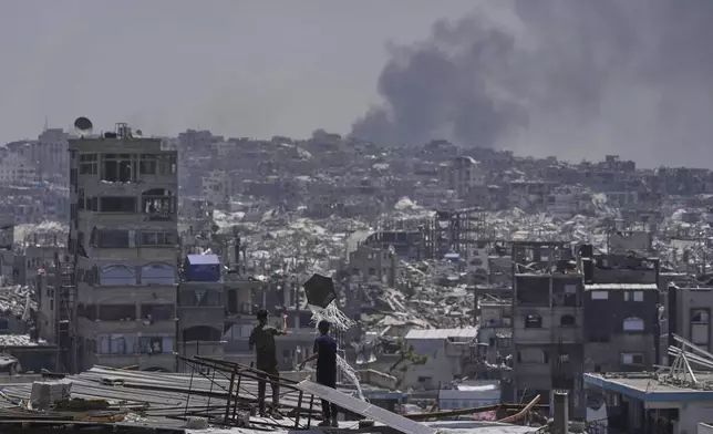 Palestinians look at smoke rises following an Israeli airstrike near Jabalia, northern Gaza Strip, Friday, May 16, 2025. (AP Photo/Jehad Alshrafi)