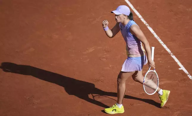 Poland's Iga Swiatek celebrates after beating Britain's Emma Raducanu at the end of their second round match of the French Tennis Open, at the Roland-Garros stadium, in Paris, Wednesday, May 28, 2025. (AP Photo/Christophe Ena)