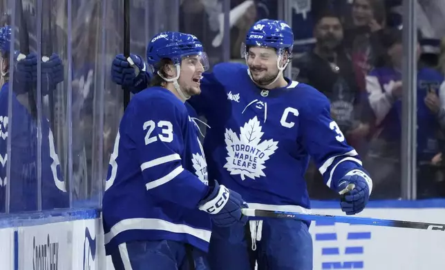 Toronto Maple Leafs forward Matthew Knies (23) celebrates after his goal with teammate Auston Matthews (34) during the third period of Game 1 in an NHL hockey second-round playoff series against the Florida Panthers in Toronto, Monday, May 5, 2025. (Nathan Denette/The Canadian Press via AP)