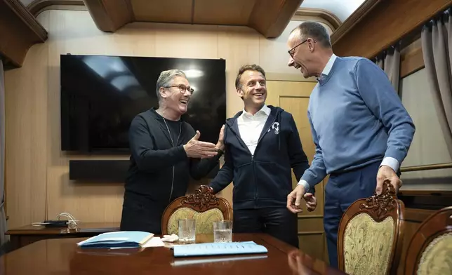 Britain's Prime Minister Keir Starmer, left, meets with French President Emanuel Macron, center, and German Chancellor Friedrich Merz onboard a train to the Ukrainian capital Kyiv where all three will hold meetings with Ukrainian President Volodymyr Zelenskyy Friday, May 9, 2025. (Stefan Rousseau/Pool Photo via AP)