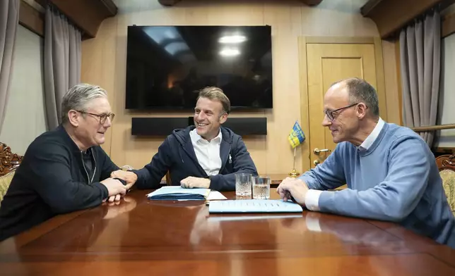 Britain's Prime Minister Keir Starmer, left, meets with French President Emanuel Macron, center, and German Chancellor Friedrich Merz onboard a train to the Ukrainian capital Kyiv where all three will hold meetings with Ukrainian President Volodymyr Zelenskyy Friday, May 9, 2025. (Stefan Rousseau/Pool Photo via AP)