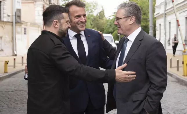 Ukrainian President Volodymyr Zelensky, left, Britain's Prime Minister Keir Starmer, right, and French President Emmanuel Macron, center, talk during a meeting in Kyiv, Ukraine, Saturday, May 10, 2025. (Stefan Rousseau/PA via AP, Pool)