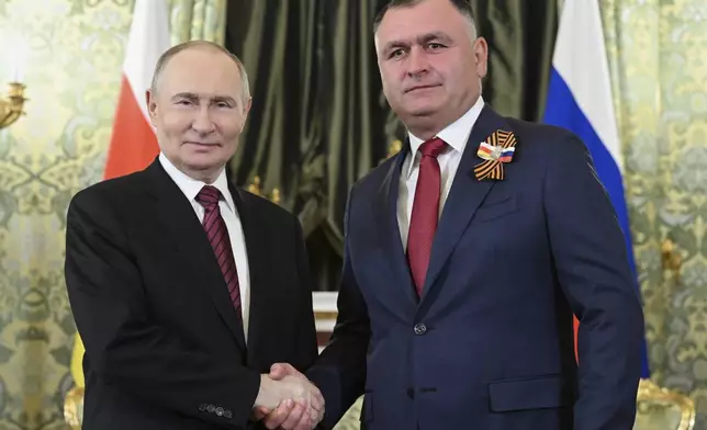 Russian President Vladimir Putin, left, and South Ossetian President Alan Gagloyev pose for a photo during their meeting in the Grand Palace at the Kremlin in Moscow, Russia, on Saturday, May 10, 2025, during celebrations of the 80th anniversary of the Soviet Union's victory over Nazi Germany during the World War II. (Sergei Bobylev/RIA Novosti via AP)