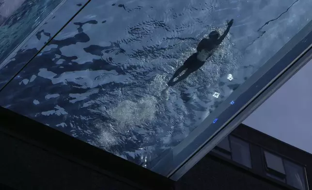 A man swims in the Sky Pool on a sunny day in London, Thursday, May 1, 2025. (AP Photo/Kin Cheung)