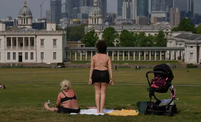 People sunbathe on a sunny day at a park in London, Thursday, May 1, 2025. (AP Photo/Kin Cheung)