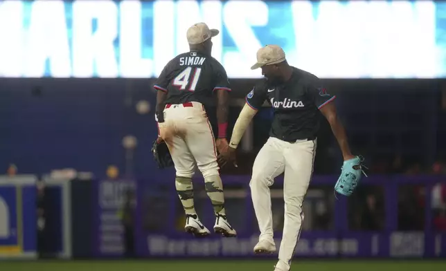 Miami Marlins outfielder Ronny Simon (41) and outfielder Jesús Sánchez celebrate after defeating the Tampa Bay Rays during a baseball game, Friday, May 16, 2025, in Miami. (AP Photo/Marta Lavandier)