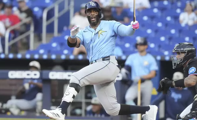 Tampa Bay Rays' Yandy Díaz (2) holds on to what remains of his broken bat during the first inning of a baseball game against the Miami Marlins, Friday, May 16, 2025, in Miami. (AP Photo/Marta Lavandier)