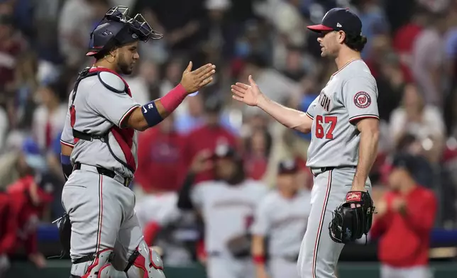 Washington Nationals pitcher Kyle Finnegan, right, and catcher Keibert Ruiz celebrate after the Nationals won a baseball game against the Philadelphia Phillies, Thursday, May 1, 2025, in Philadelphia. (AP Photo/Matt Slocum)