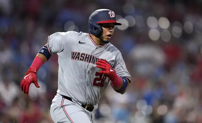 Washington Nationals' Keibert Ruiz runs to first after batting in a run on a fielding error by Philadelphia Phillies first baseman Bryce Harper during the sixth inning of a baseball game, Thursday, May 1, 2025, in Philadelphia. (AP Photo/Matt Slocum)