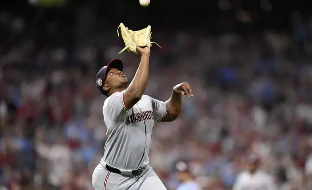 Washington Nationals pitcher Jose A. Ferrer fields a run-scoring single by Philadelphia Phillies' Nick Castellanos during the sixth inning of a baseball game, Thursday, May 1, 2025, in Philadelphia. (AP Photo/Matt Slocum)
