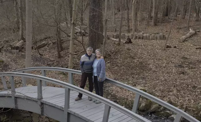 Jon Randall, left, and Mariane Randall, right, pose for a portrait at their home on Saturday, March 22, 2025, in Webster, N.Y. (Toni Duncan via AP)