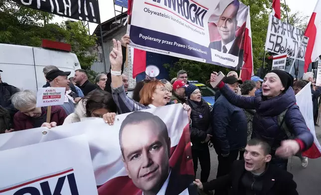 People carry placards in support of conservative presidential candidate Karol Nawrocki in Warsaw, Poland, Tuesday, May 13, 2025. (AP Photo/Czarek Sokolowski)