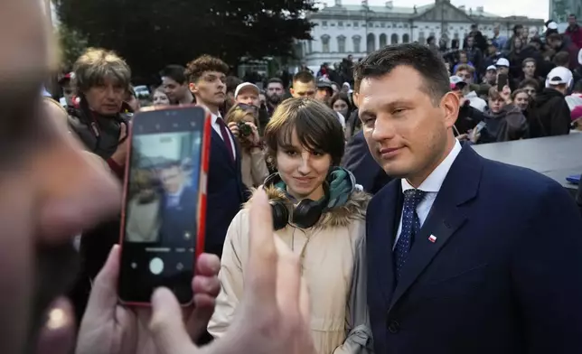 Far-right Confederation party's presidential candidate Sławomir Mentzen poses for a photo with supporters in Saturday,Warsaw, Poland, May 10, 2025. (AP Photo/Czarek Sokolowski)