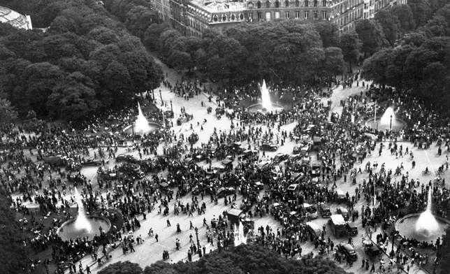 FILE - Happy crowds gather round the Rond-Point on the Champs-Elysees, Paris, France, on V-E Day, May 8, 1945, to celebrate the announcement of Germany's unconditional surrender. (AP Photo/Henry L. Griffin, File)