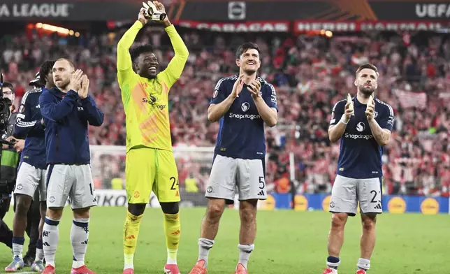 Manchester United's Christian Eriksen, Manchester United's goalkeeper Andre Onana, Manchester United's Harry Maguire, Manchester United's Luke Shaw, from left, celebrate their victory at the Europa League semifinal first leg soccer match between Athletic Bilbao and Manchester United at the San Mames stadium in Bilbao, Spain, Thursday, May 1, 2025. (AP Photo/Miguel Oses)