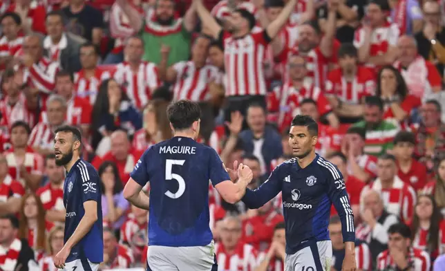 Manchester United's Casemiro, right, celebrates after scoring his side's opening goal during the Europa League semifinal first leg soccer match between Athletic Bilbao and Manchester United at the San Mames stadium in Bilbao, Spain, Thursday, May 1, 2025. (AP Photo/Miguel Oses)