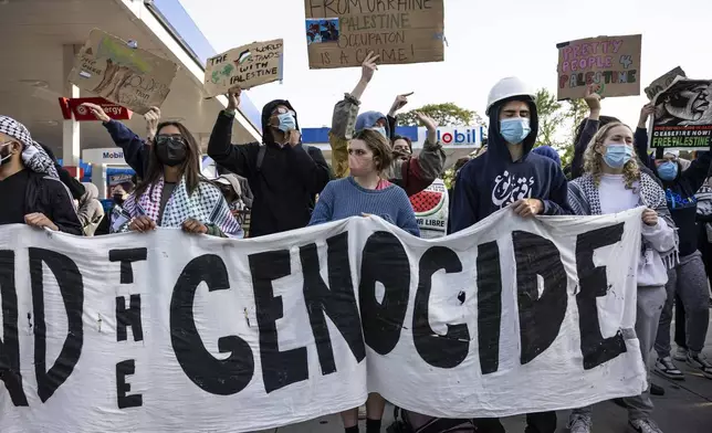 FILE - Chicago police officers keep watch as protesters rally on Fullerton Avenue while crews disassemble the pro-Palestinian encampment in the quad at DePaul University's Lincoln Park campus in Chicago, May 16, 2024. (Ashlee Rezin/Chicago Sun-Times via AP, file)