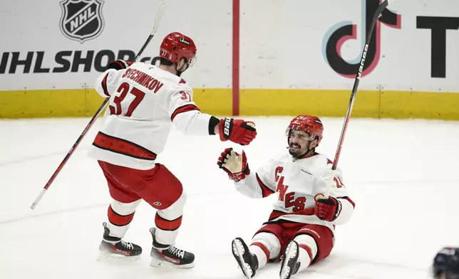 Carolina Hurricanes center Seth Jarvis (24) celebrates his empty net goal with right wing Andrei Svechnikov (37) in the third period of Game 5 of a second-round NHL hockey playoff series against the Washington Capitals Thursday, May 15, 2025, in Washington. (AP Photo/Nick Wass)
