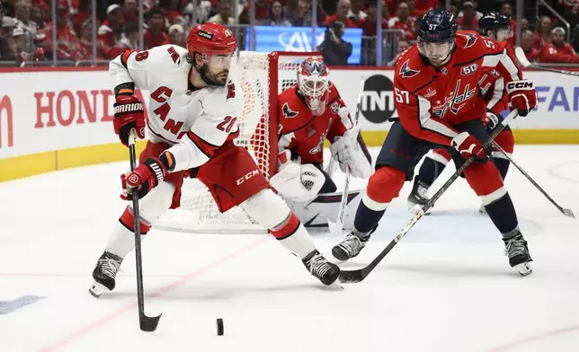 Carolina Hurricanes left wing William Carrier (28) skates with the puck against Washington Capitals defenseman Trevor van Riemsdyk (57) in the second period of Game 5 of a second-round NHL hockey playoff series Thursday, May 15, 2025, in Washington. (AP Photo/Nick Wass)