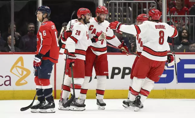 Carolina Hurricanes center Jordan Staal (11) celebrates his goal with teammates in the first period of Game 5 of a second-round NHL hockey playoff series as Washington Capitals defenseman Jakob Chychrun (6) skates by Thursday, May 15, 2025, in Washington. (AP Photo/Nick Wass)