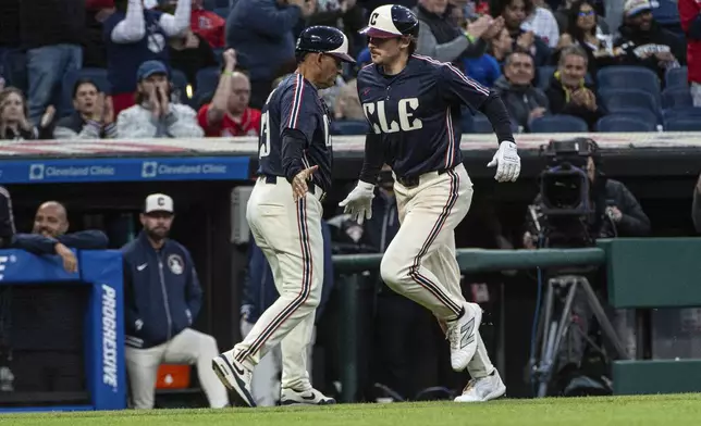 Cleveland Guardians' Kyle Manzardo, right, is congratulated by third base coach Rouglas Odor after hitting a solo home run off Philadelphia Phillies starting pitcher Aaron Nola during the fourth inning of a baseball game Friday, May 9, 2025, in Cleveland. (AP Photo/Phil Long)