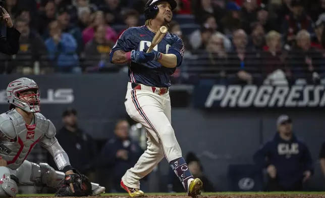 Cleveland Guardians' Jose Ramirez, right, watches his solo home run off Philadelphia Phillies relief pitcher Joe Ross as Phillies catcher Rafael Marchan, left, looks on during the seventh inning of a baseball game Friday, May 9, 2025, in Cleveland. (AP Photo/Phil Long)