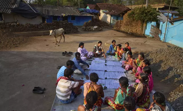 Members of Paroja Indigenous community discuss the maps they have made in Hatipakna village, Koraput district, in India's eastern state of Odisha, Thursday, April 17, 2025. (AP Photo/Rafiq Maqbool)