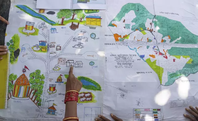 Kamala Kadria, a woman from the Gadaba Indigenous community, points to a spot on a map they made in Hatipakna village, Koraput district, in India's eastern state of Odisha, Wednesday, April 16, 2025. (AP Photo/Rafiq Maqbool)