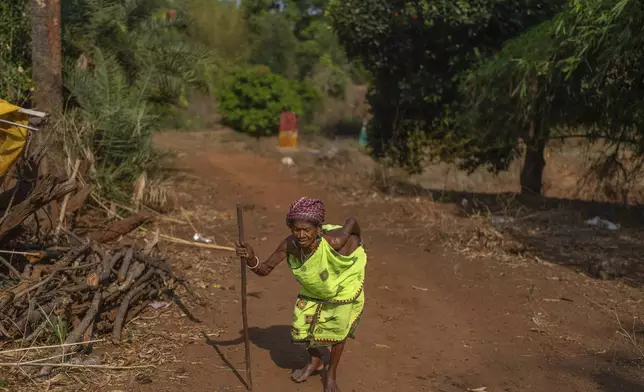 A woman, from the Durua tribe, which is part of the Indigenous Adivasis communities, walks toward her house in Pongan Pani village, Koraput district, in India's eastern state of Odisha, Wednesday, April 16, 2025. (AP Photo/Rafiq Maqbool)