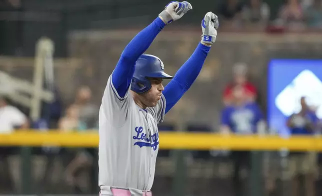 Los Angeles Dodgers' Freddie Freeman celebrates after hitting a double while scoring Mookie Betts against the Arizona Diamondbacks during the first inning of a baseball game Sunday, May 11, 2025, in Phoenix. (AP Photo/Darryl Webb)