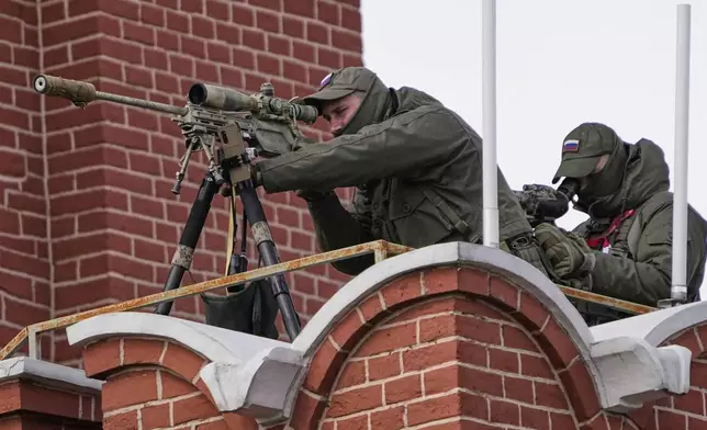 A security service officer aims his sniper rifle securing the area during the Victory Day military parade in Moscow, Russia, Friday, May 9, 2025, during celebrations of the 80th anniversary of the Soviet Union's victory over Nazi Germany in the World War II. (AP Photo/Alexander Zemlianichenko)