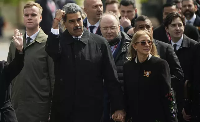 Venezuela's President Nicolas Maduro gestures as he walks with his wife Cilia Flores in Red square after the Victory Day military parade in Moscow, Russia, Friday, May 9, 2025, during celebrations of the 80th anniversary of the Soviet Union's victory over Nazi Germany during the World War II. (AP Photo/Pavel Bednyakov, Pool)