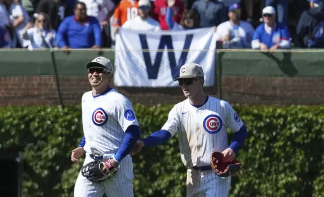 Chicago Cubs' Pete Crow-Armstrong, right, celebrates with Seiya Suzuki, left,of Japan, after they defeated the Chicago White Sox in a baseball game in Chicago, Sunday, May 18, 2025. (AP Photo/Nam Y. Huh)
