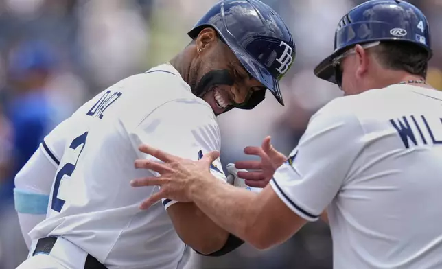 Tampa Bay Rays' Yandy Díaz jokes with third base coach Brady Williams (4) after Diaz hit a solo home run off Kansas City Royals pitcher Seth Lugo during the first inning of a baseball game Thursday, May 1, 2025, in Tampa, Fla. (AP Photo/Chris O'Meara)