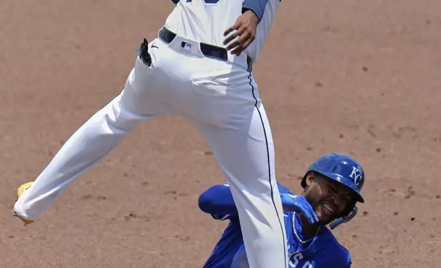Kansas City Royals' Maikel Garcia steals third base under Tampa Bay Rays' Junior Caminero (13) during the second inning of a baseball game Thursday, May 1, 2025, in Tampa, Fla. (AP Photo/Chris O'Meara)