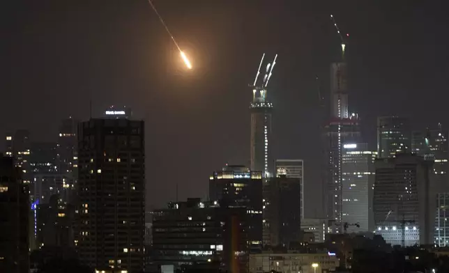 The trace of a projectile is seen before hitting Tel Aviv, Israel, early Saturday, June 14, 2025. (AP Photo/Leo Correa)