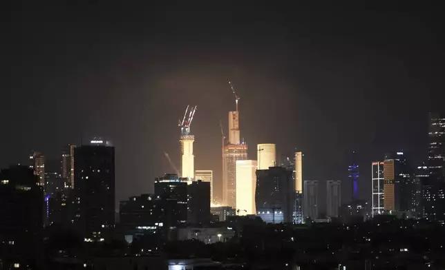 A projectile hits buildings in Tel Aviv, Israel, early Saturday, June 14, 2025. (AP Photo/Leo Correa)