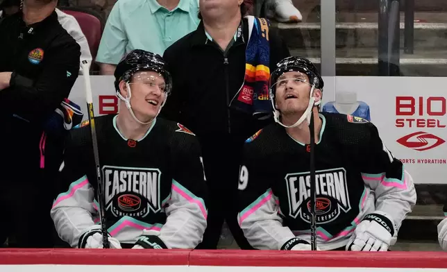 FILE - Atlantic Division's Brady Tkachuk, of the Ottawa Senators (7) and Matthew Tkachuk, of the Florida Panthers (19) watch the rerun of a goal by Matthew assisted by Brady during the NHL All Star hockey game, Feb. 4, 2023, in Sunrise, Fla. (AP Photo/Marta Lavandier, File)