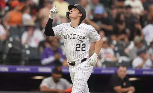Colorado Rockies' Mickey Moniak gestures as he circles the bases after hitting a solo home run off San Francisco Giants starting pitcher Hayden Birdsong in the sixth inning of a baseball game, Thursday, June 12, 2025, in Denver. (AP Photo/David Zalubowski)