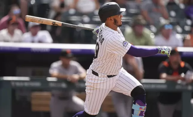 Colorado Rockies' Thairo Estrada doubles off San Francisco Giants relief pitcher Randy Rodríguez in the ninth inning of a baseball game Thursday, June 12, 2025, in Denver. (AP Photo/David Zalubowski)